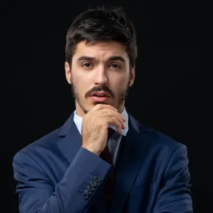 front view young thoughtful bearded man posing isolated dark wall (1).png